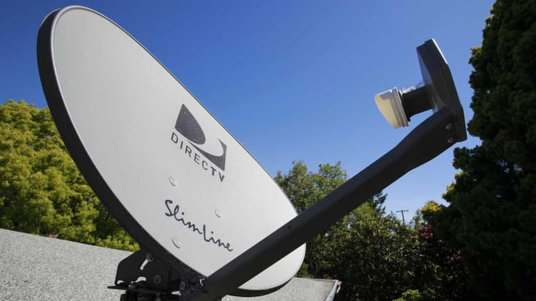 A DirecTV satellite dish is attached to a roof at...