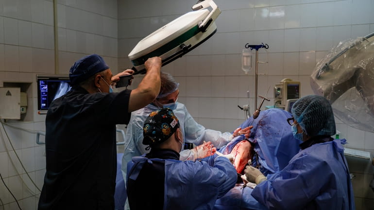 Petro Nikitin, left, takes part a surgery operation of Ukrainian...