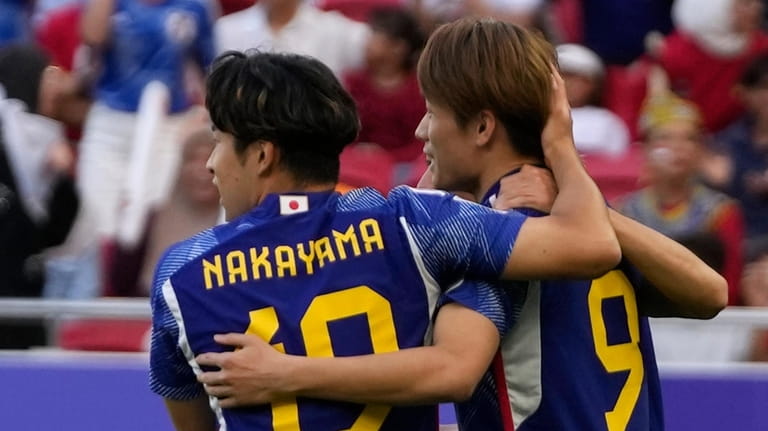 Japan's Ayase Ueda, right, celebrates with his team mate after...