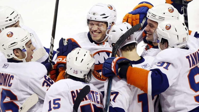 New York Islanders right wing Kyle Okposo, center, celebrates with...