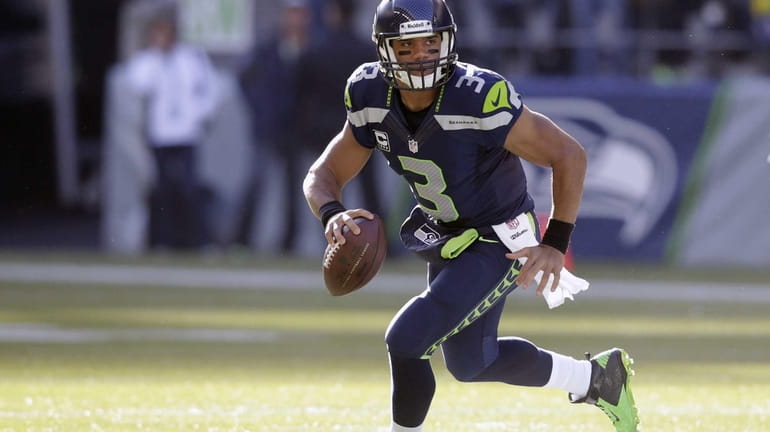 Seattle Seahawks quarterback Russell Wilson scrambles during the first half...