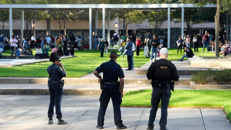 Houston Police officers watch over displaced churchgoers outside Lakewood Church,...