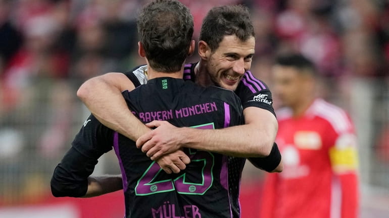 Bayern's Thomas Mueller celebrates with his teammate Leon Goretzka after...