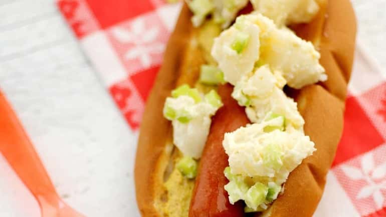 Hot dog topped with potato salad and spicy brown mustard....