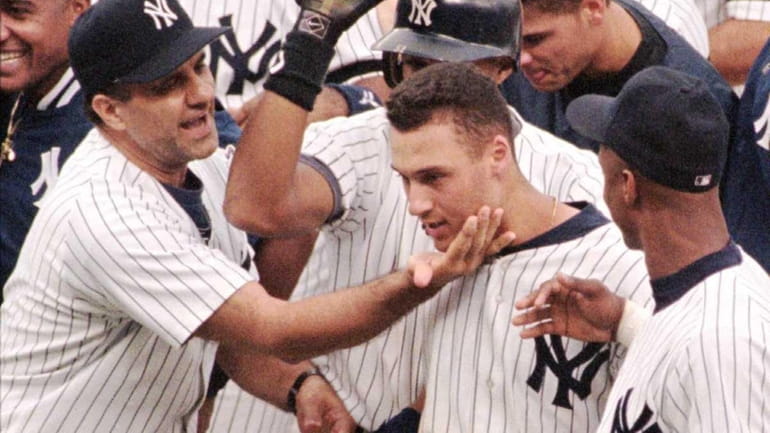 Yankees manager Joe Torre, left, pats Derek Jeter, center, on...