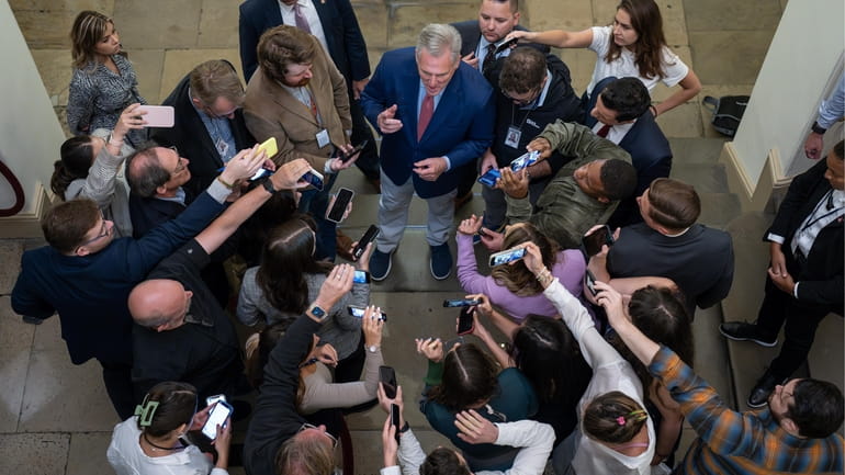 House Speaker Kevin McCarthy is surrounded by reporters looking for...