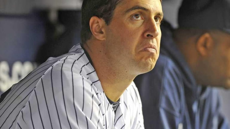 Mark Teixeira watches the game from the bench as he...