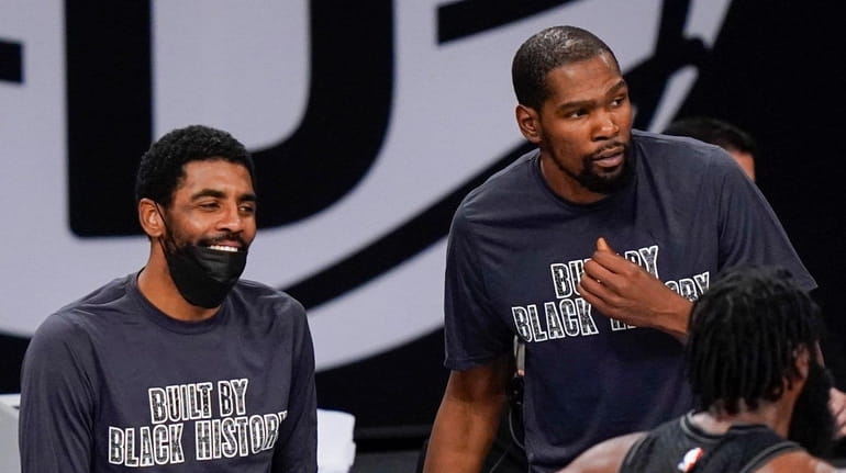 Nets guard Kyrie Irving and forward Kevin Durant wait to...