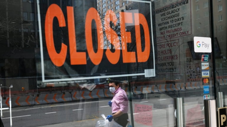 A closed sign displayed in the window of a business in...