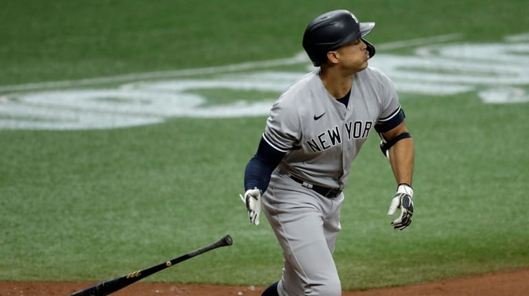 Yankees' Giancarlo Stanton drops his bat as he watches his...