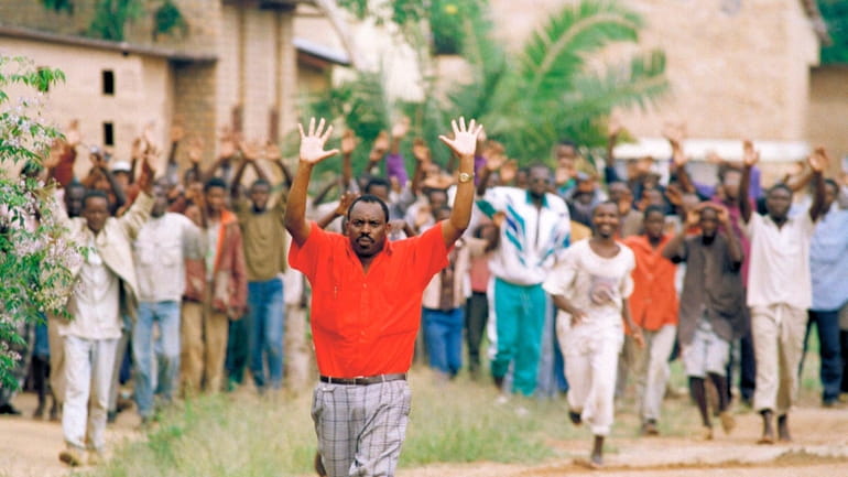 Rwandan refugees hold their hands up and ask for help...