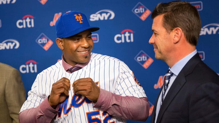 Yoenis Cespedes tries on his Mets jersey during a news...