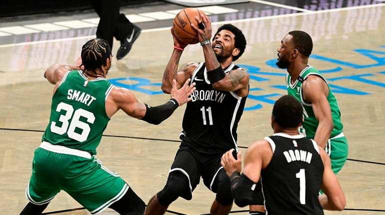 Kyrie Irving #11 of the Nets drives to the basket...