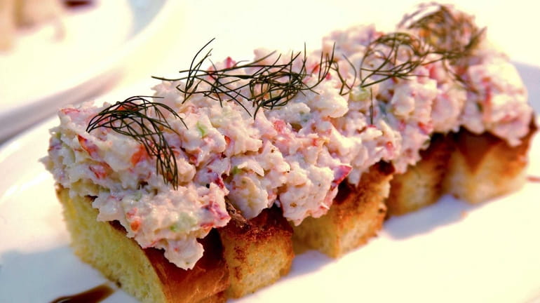 A Luce & Hawkins mini lobster roll is served with...