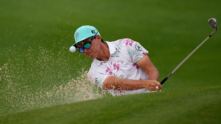 Rickie Fowler plays a shot from a bunker on the...