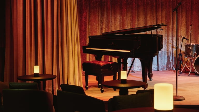 A baby grand piano sits on the stage at the...