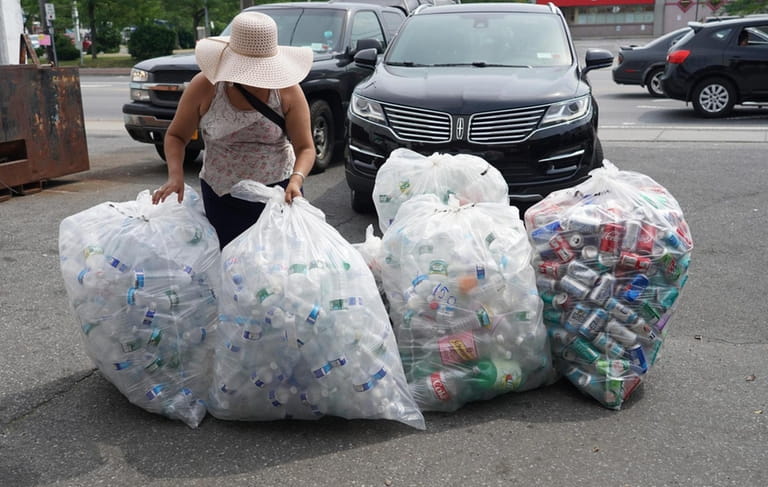 A woman brings bottles and cans to a redemption center...
