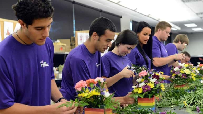 Interns at 1-800-Flowers assemble arrangements during training at the company's...