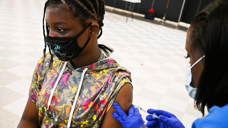 Sharisse Lowery, 13, of Freeport, gets a COVID-19 vaccine at Freeport High...
