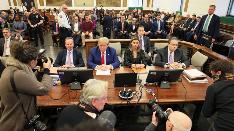 Former President Donald Trump, center, sits in the courtroom before...