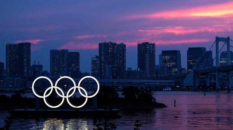The Olympic rings lit up at dusk, with the Rainbow...