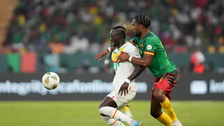 Senegal's Sadio Mane, left, is challenged by Cameroon's Enzo Tchato...