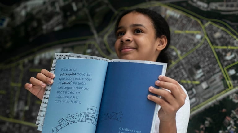 Myrella Victoria Viana dos Santos, 10, shows the book titled...