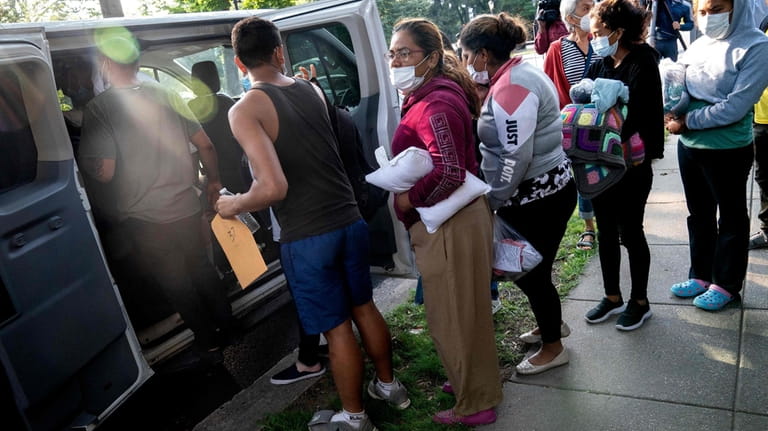 Migrants from Venezuela, who boarded a bus in Texas, wait...