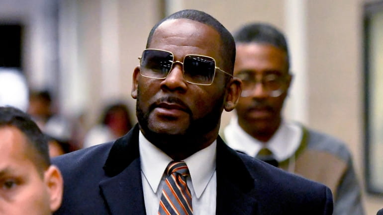 R. Kelly, center, leaves the Daley Center after a hearing...