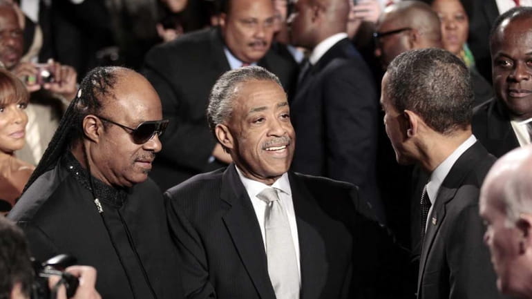 President Barack Obama, right, greets recording artist Stevie Wonder, left,...