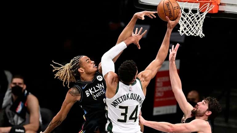 Giannis Antetokounmpo #34 of the Milwaukee Bucks is defended by...