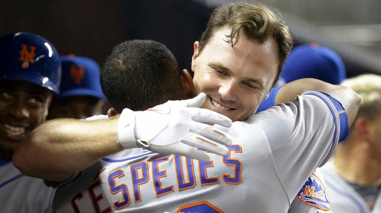 New York Mets' Jay Bruce, right, hugs Yoenis Cespedes (52)...