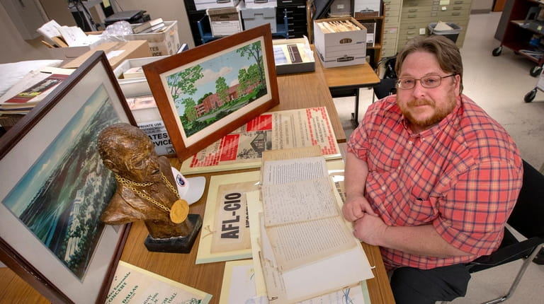 Adelphi University archivist David Ranzan is shown with items saved...