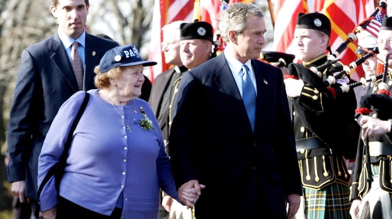 President George W. Bush walks with Arlene Howard in 2004...