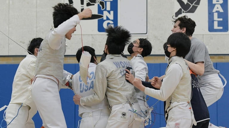 The Great Neck South boys fencing team reacts with joy...