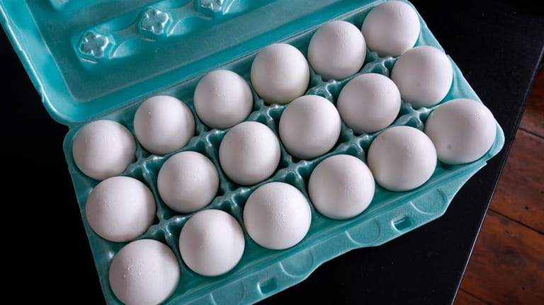 A carton of eggs sits on a kitchen counter on...