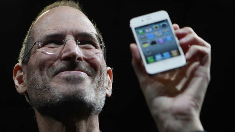 Apple chief executive Steve Jobs holds the new iPhone 4...