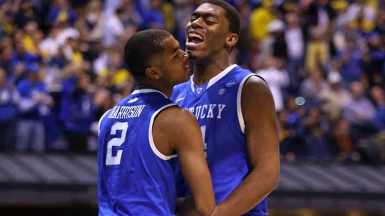 Kentucky's Dakari Johnson celebrates with teammate Aaron Harrison after a...