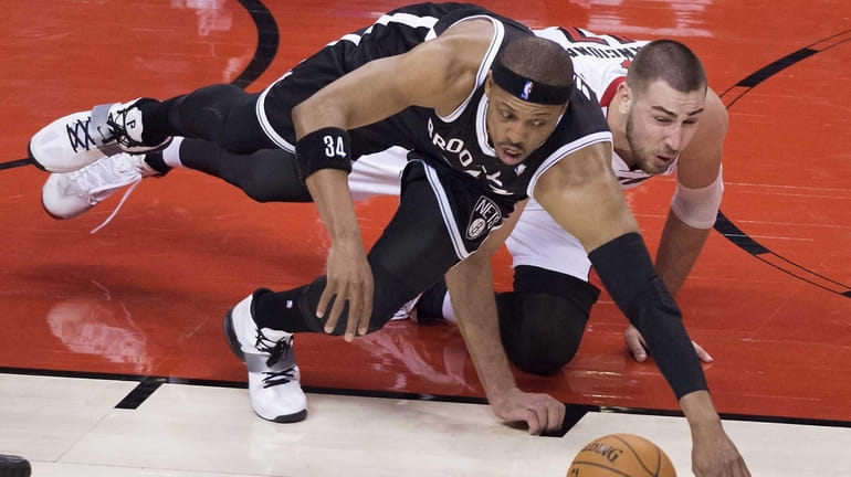 Nets' Paul Pierce, left, and Toronto Raptors' Jonas Valanciunas dive...