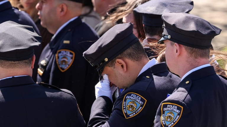 An NYPD officer grieves at Diller's funeral in Massapequa.