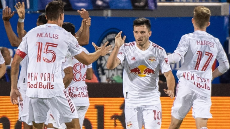 The Red Bulls' Lewis Morgan celebrates with teammates after scoring against...
