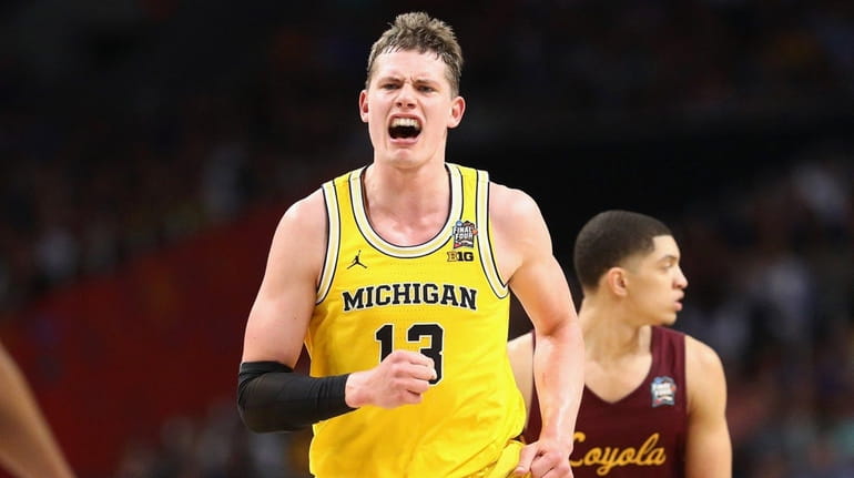 Moritz Wagner #13 of the Michigan Wolverines celebrates after a...