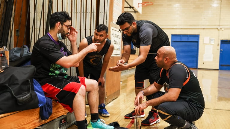 During a break in Crescent League play, basketball players Naveed...