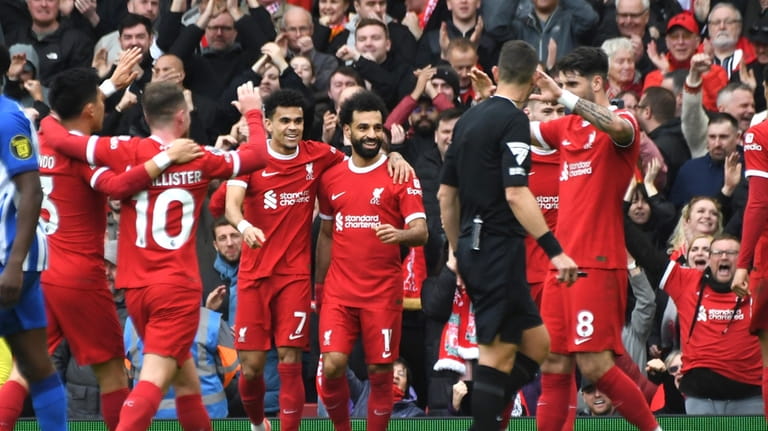 Liverpool's Mohamed Salah, centre, celebrates with teammates after scoring his...