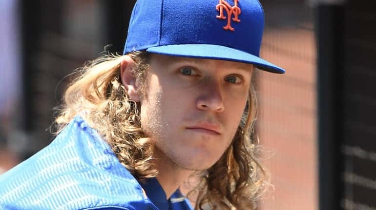Mets pitcher Noah Syndergaard looks on from the dugout against...