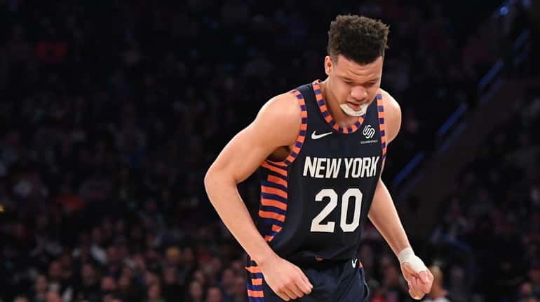 Knicks forward Kevin Knox favors his right foot after being...