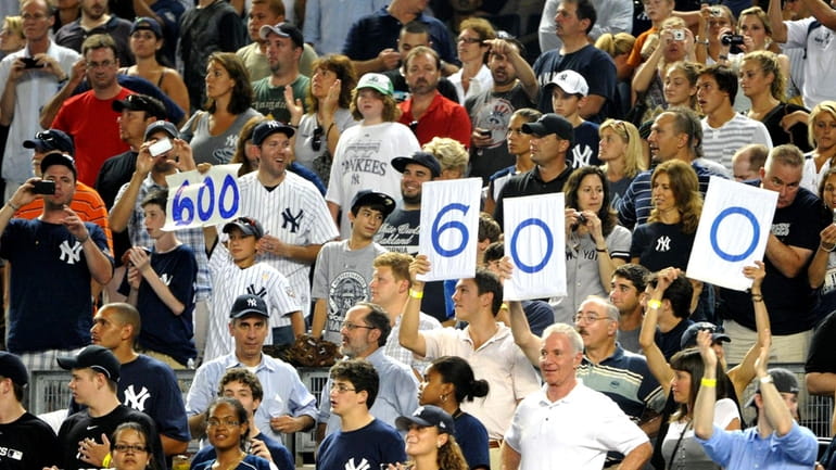 Fans hold up signs reading "600" in reference to the...
