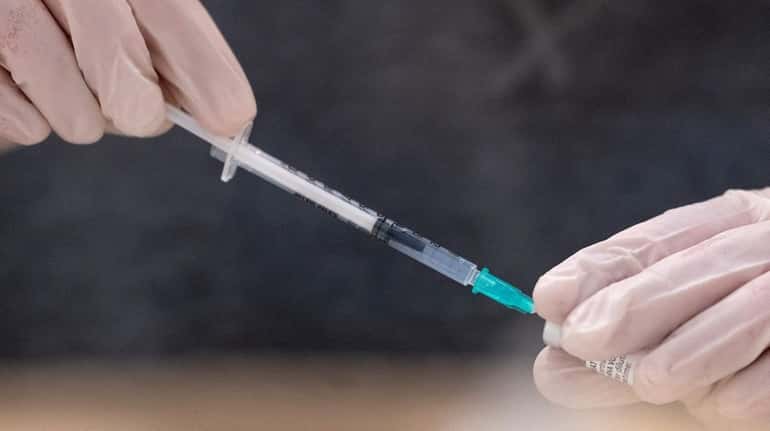 A nurse fills a syringe with the vaccine by Pfizer/BioNTech.