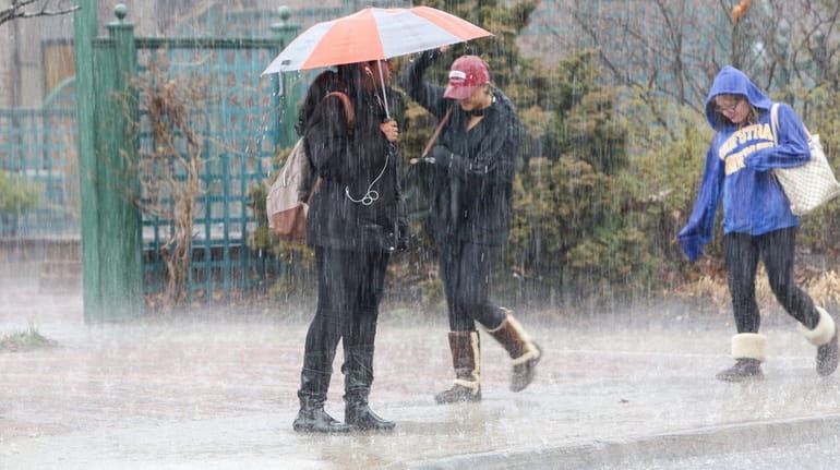 Pedestrians deal with drenching rain as they wait to cross...