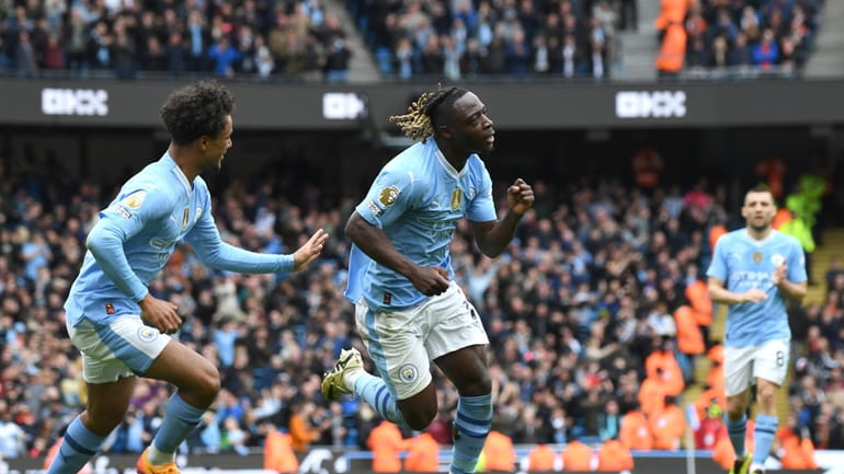 Manchester City's Jeremy Doku, centre, celebrates after scoring his side's...